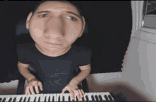 a man with a big nose is playing a piano .