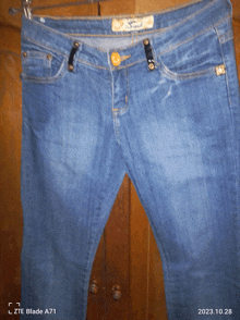 a pair of jeans hanging on a hanger with a date stamp of 2022.10.28