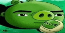 a green angry bird is holding a smaller green pig in its mouth .