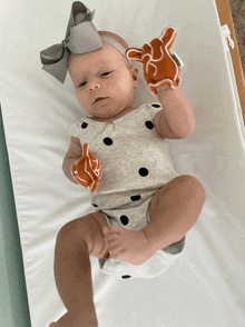 a baby laying on a changing table with a headband on