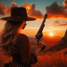 a woman in a hat holds a gun in front of a sunset