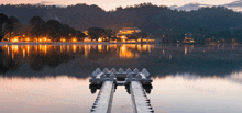 a dock in the middle of a lake with a castle in the background