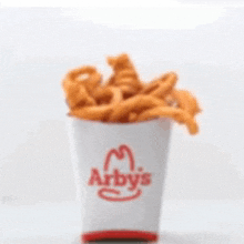 a cup of french fries from arby 's on a table