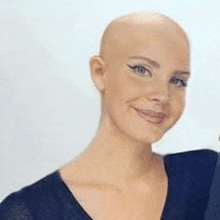 a close up of a woman with a bald head smiling .