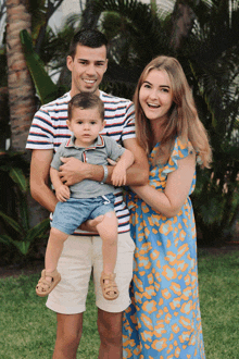 a man in a striped shirt is holding a baby boy