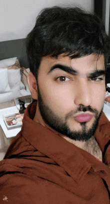 a man with a beard is taking a selfie in a bedroom