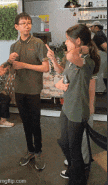 a boy and a girl are standing next to each other in a restaurant