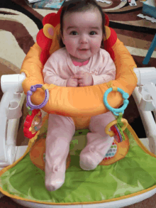 a baby is sitting in a high chair with toys