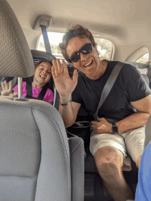 a man sitting in the back seat of a car with a little girl