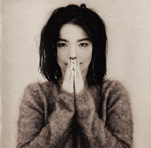 a black and white photo of a woman covering her face with her hands