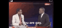 a man in a suit and tie is talking to another man in a suit and tie who is saying " you are gay "