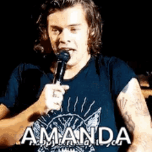 harry styles is holding a microphone in his hand and talking into it .