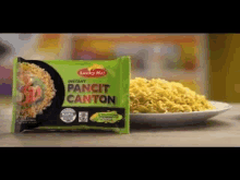 a bag of pancit canton noodles is sitting next to a plate of noodles .