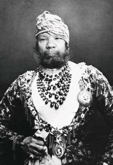 a black and white photo of a man with a beard wearing a turban