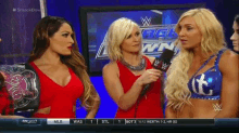 a group of women are standing next to each other in front of a microphone on a wrestling show .