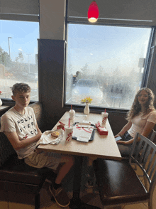 a boy wearing a hollister shirt sits at a table