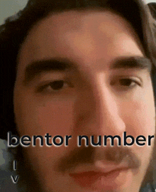 a close up of a man 's face with bentor number written on the bottom