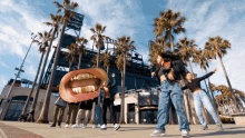 a group of people are posing for a picture in front of a stadium that has the word giants on it