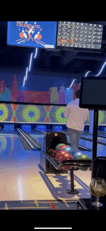 a man is playing bowling in a bowling alley with a sign above him that says celebrate