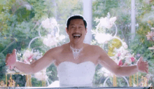 a man in a wedding dress is standing with his arms outstretched and smiling .