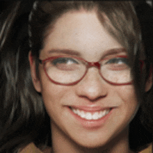 a close up of a woman 's face with glasses smiling