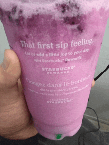 a person is holding a starbucks cup that says " that first sip feeling "