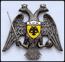 a statue of a double headed eagle with the letters a.c.k. on the shield