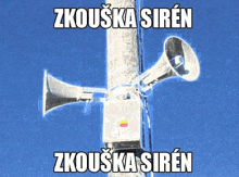 a couple of speakers on a pole with the words " zkouska siren " on the top