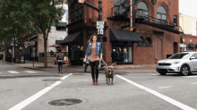 a woman is walking a dog on a leash in front of a sign that says ' no parking '