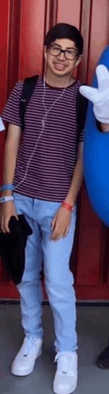 a young man wearing glasses and a striped shirt is posing for a picture