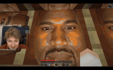 a man playing a video game with a screenshot of kanye west 's face on the screen