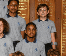 a group of young boys are posing for a picture in front of a plaque that says brownley on it