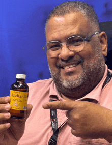 a man holds a bottle of azahar and points at it