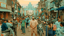 a man stands in the middle of a crowded street with a sign on the wall that says ' shree ram '