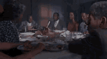 a group of people are sitting at a table eating food .