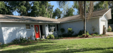 a white house with a red door and a oval window