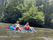 two girls in bikinis are floating down a river in inner tubes