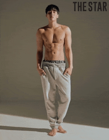 a shirtless man wearing calvin klein underwear is standing in front of a white wall .