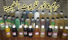 a bunch of bottles are lined up on a table with arabic writing