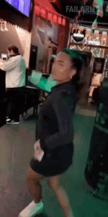 a woman in a black dress is dancing in a bar with failarmy written in the corner