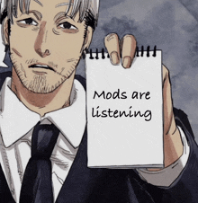 a man in a suit and tie holds up a notepad that says mods are listening