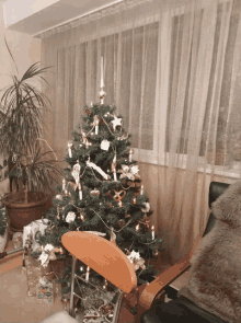 a christmas tree in a living room with a chair