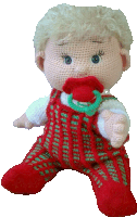 a crocheted baby doll is holding a pacifier