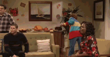 a group of people in a living room with a sign that says thanksgiving on the wall