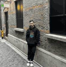 a man is leaning against a brick wall in a narrow alleyway .