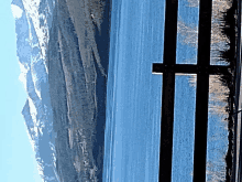 a view of a lake with mountains in the background and a cross in the foreground