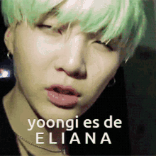 a close up of a person 's face with the words " yoongi es de eliana " on the bottom