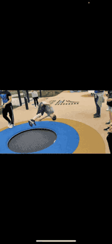 a person is doing a handstand on a trampoline while people watch .