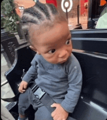 a baby is sitting on a bench with a seat belt around his waist .