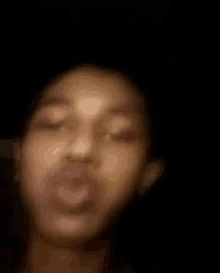 a blurry picture of a person 's face with their mouth open .